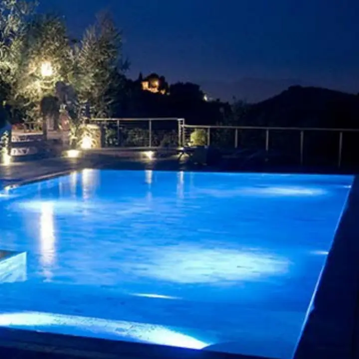 Ellipsis underwater lights glowing in a lit swimming pool