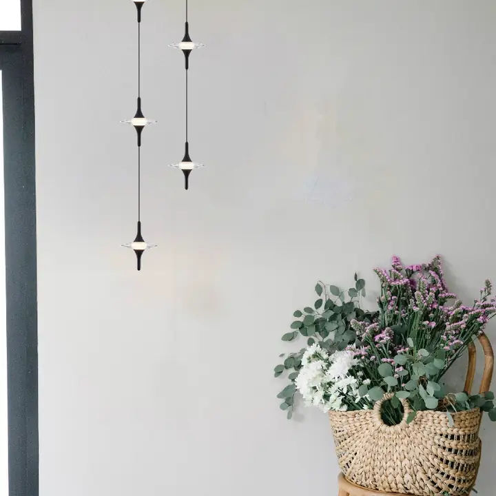 Lusso pendants with slim crystal drops beside a plant