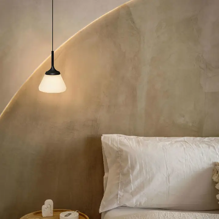 Paul pendant with an opal glass shade above a bedside table