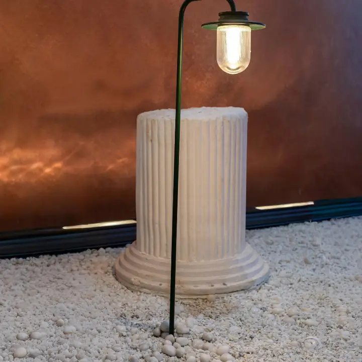 Tron bollard lighting a fluted stone column on pale gravel