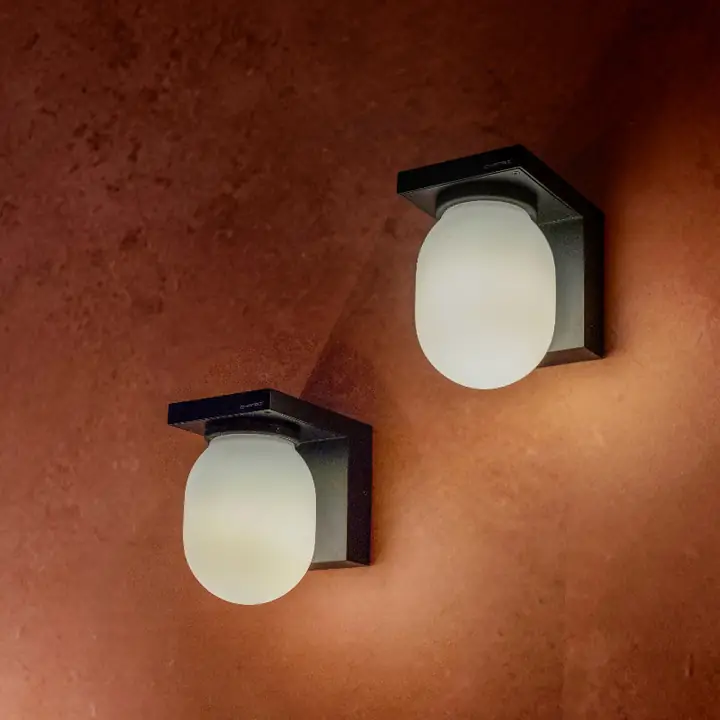 Vega opal glass sconces on a warm plaster wall