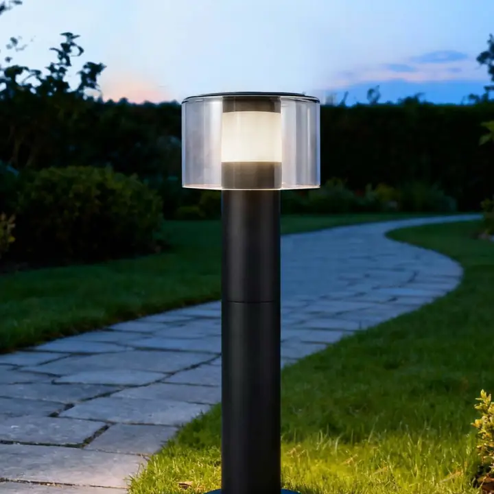Zeta bollard beside a paved garden path at dusk